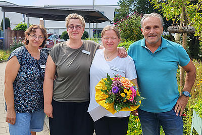 Foto mit 4 Personen. Darauf zu sehen von links nach rechts sind Frau Frieda Dittert, Frau Anja Heidenreich (stellvertr. Leitung), Frau Regina Welling (Jubilarin), Geschäftsführer Jens Schickel