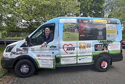 Foto des Autos mit AWO Geschäftsführer Rainer Kleßmann auf dem Fahrersitz mit geöffneter Tür